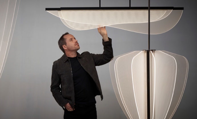 A person touching a light fixture Description automatically generated