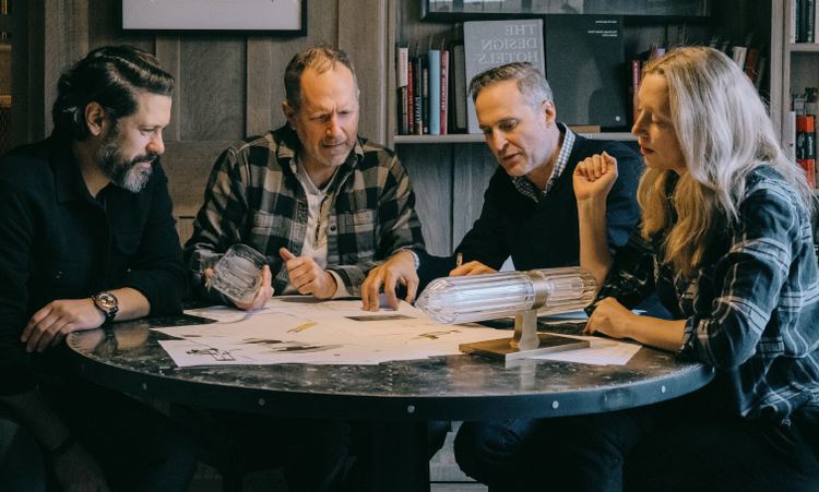 A group of people sitting around a table looking at a piece of paper Description automatically generated