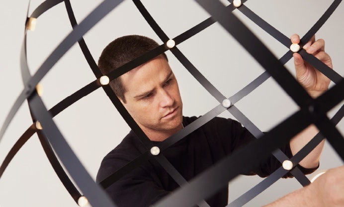 A person looking through a metal lattice Description automatically generated