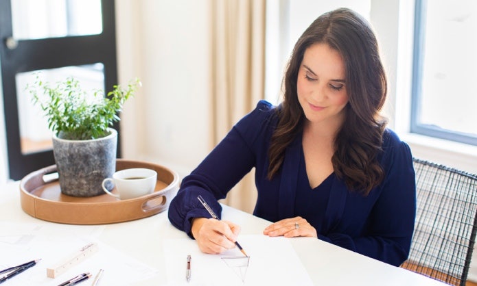 A person drawing on paper Description automatically generated